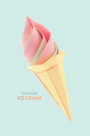 Fruit pink and green ice cream in the cone  origami paper desert on a blue backgroundの写真素材