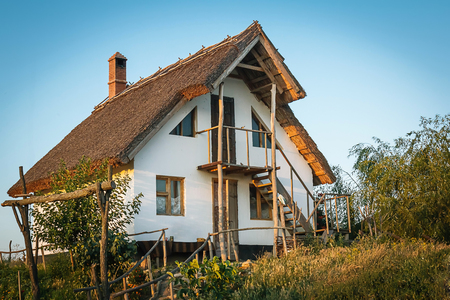 Farmhouse wooden window on white whitewash facade and reed roofの写真素材