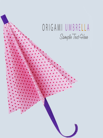 Origami pink polka-dot protection umbrella on a gray backgroundの写真素材