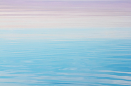 Lake tranquil pink blue water waves backgroundの写真素材