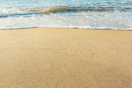 Sand golden beach with blue wave blank backgroundの写真素材