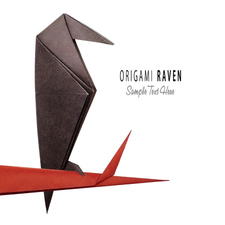 Origami paper halloween raven isolated on tree branchの写真素材