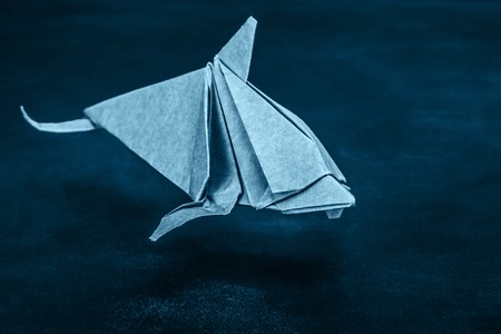 Dolphin origami of kraft paper jumping on blackboard backgroundの写真素材