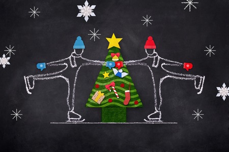 Chelk sketch of couple skating on ice rink with Christmas tree hand drawn illustration on black boardの写真素材