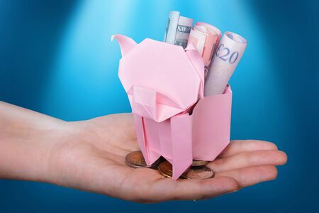 Piggy bank looking up for the coin with lights on blueの写真素材