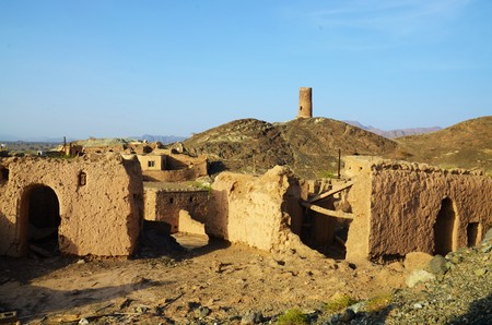 Ruins of a former village, in the background a tower on top of a hill during a sunny dayの写真素材
