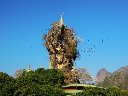 Incredible Kyauk Kalap Pagoda under blue sky, birds are fliying around it in Hpa-An, Myanmarの写真素材