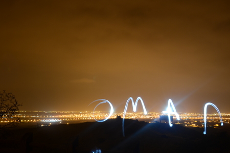"Oman" written with light, city view of Salalah from a hill by nightの写真素材