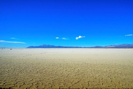Long shot of the Salinas Grandes salt flats in North Argentina at the foot of the Sierras de Cordoba mountain range in South Americaの写真素材