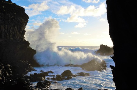 Waves breaking at the cliffs in front of the Ana Kai Tangata Cave close to Hanga Roa in Rapa Nui, Easter Island in Chile, South Americaの写真素材