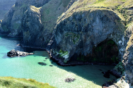 Long shot over the coastline at the Carrick-a-Rede coastal walk to the rope bridge in County Antrim,...