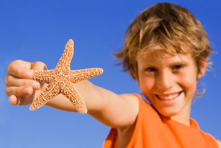 happy child on summer vacation showing starfishの写真素材