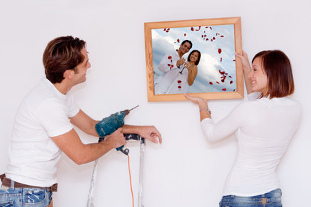 putting up picture in frame(photo in frame is mine of same couple9の写真素材