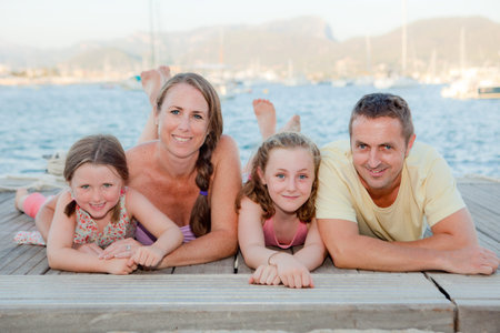 summer family smiling laying on beach.の写真素材