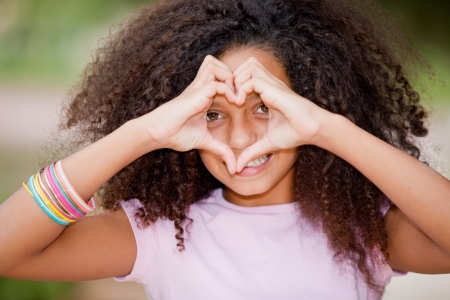 young happy smiling black girl making heart shape の写真素材