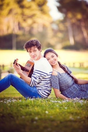 summer romance with guitar boy playing guitar for girlの写真素材