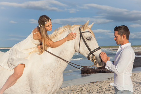 romantic couple on beach with horseの写真素材