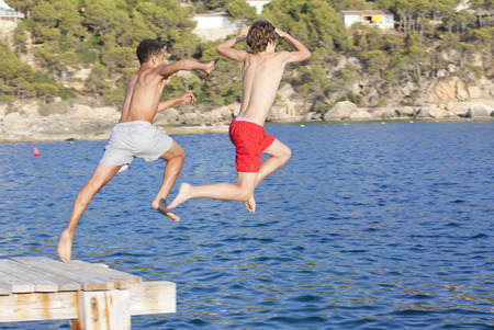 summer camp kids jumping in seaの写真素材