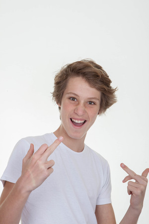 boy teen in blank white t shirt pointing at self or faceの写真素材