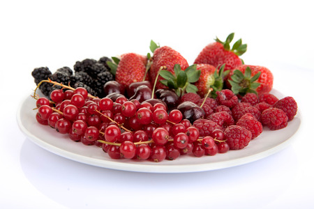 plate of fresh red summer fruits and berriesの写真素材