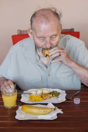 elderly man eating healthy lunch in care homeの写真素材