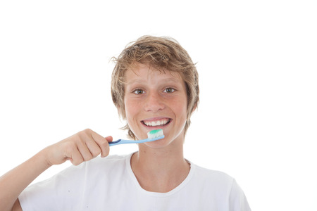 kid or teen cleaning white healthy teeth with toothbrushの写真素材