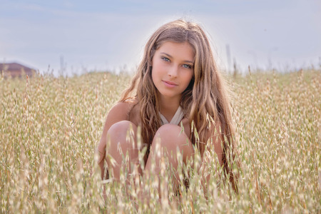 healthy young woman in summer wheat fieldの写真素材