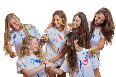 group of kids or teens girls having fun with messy paintの写真素材