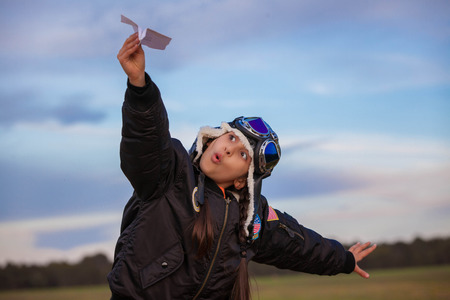 Travel kid or child playing with paper planeの写真素材