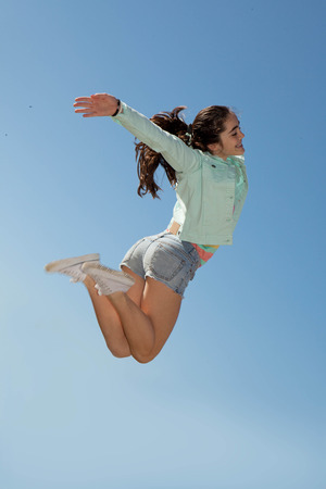 happy girl jumping or leaping with joyの写真素材