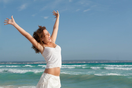happy teen on summer or spring break holdiay arms upの写真素材