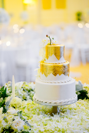 White and gold Wedding Cake decorated with flower, petals.の写真素材