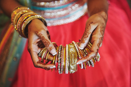 The tattoo on hand of indian bride (mehndi or henna) with bracelets and holding a lot of bracelets...