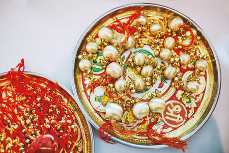 The golden choora with red thread on the plate, the items for rituals of Indian marriage ceremonyの写真素材