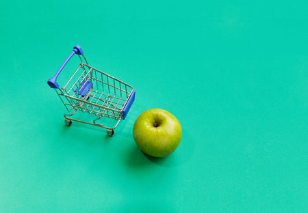 Green apples with mini shopping cart with green vintage color theme, copy space or text space