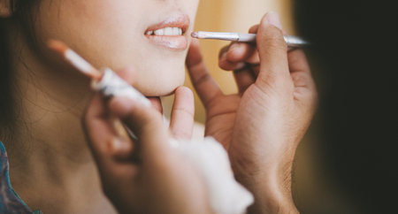 Close-up, Profesional stylist putting on lipstick on the lip of the bride during getting ready for...