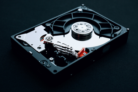 Hard drive assembly uncovered with arm read/write head and platters, Data storage equipment concepts.の写真素材