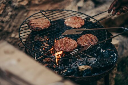 Burgers cooked on a small barbecue outdoors.の写真素材