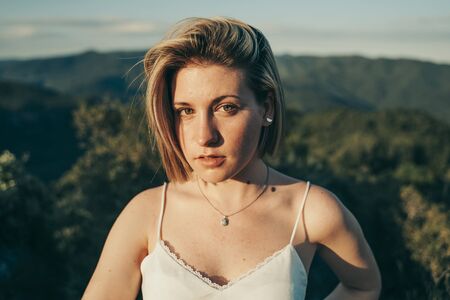 Blonde cute girl in nature landscape with a nice blue sky.の写真素材
