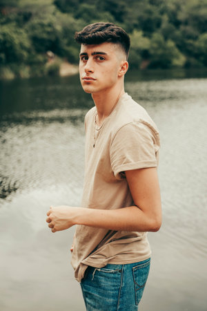Young boy model on a lake in the middle of the forest in spring season.