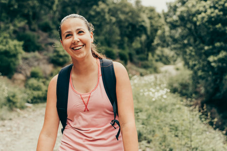Girl hiker smiling in the middle of natural landscape.