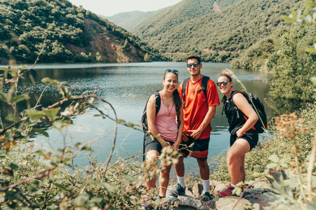 Young hikers in mountainous landscape with lake in summer.