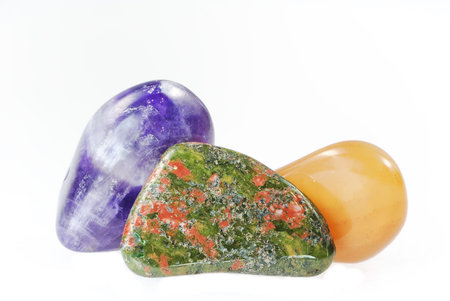 Smooth colourful pebble stones isolated on white
