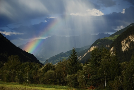 Rainbow between mountains in the alpsの写真素材