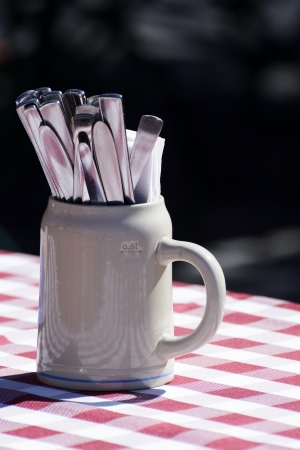 Silverware in a clay jug at a bavarian outdoor restaurantの写真素材