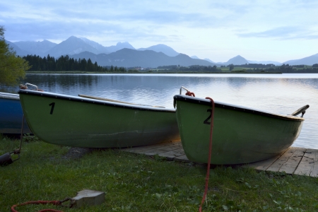 Boats at a lake in the alps of the Allgaeu (Bavaria, Germany) during sunset.の写真素材