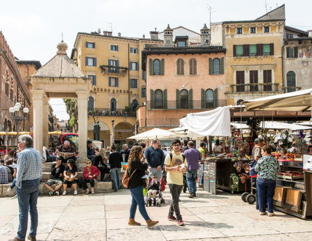 VERONA, ITALY - APRIL 23: Tourists at the historic center of  Verona, Italy - April 23, 2014. Verona is famous for its ancient amphitheatre which could host more than 30,000 spectators in ancient times. Foto taken at Piazza Delle Erbeのeditorial素材