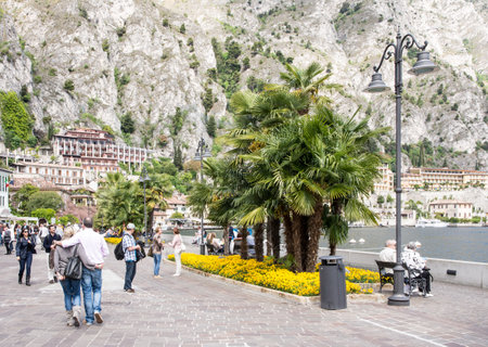 LIMONE, ITALY - APRIL 22: Tourists at the pedestrian area of Limone, Italy on April 22, 2014. The town at Lake Garda is famous for the cultivation of lemons. Foto taken from the water front in Limone.のeditorial素材