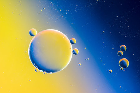Abstract macro with oil drops in water, looking like planets in space.