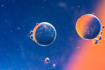 Abstract macro with oil drops in water, looking like planets in space.